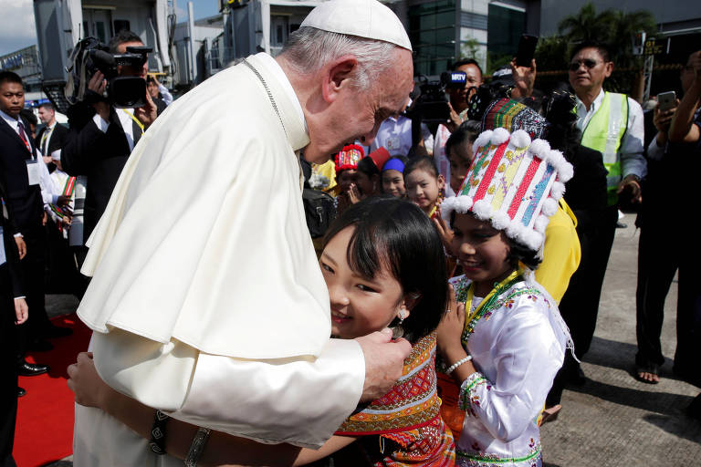 O papa Francisco � abra�ado por crian�a ao desembarcar em Yangon, em Mianmar