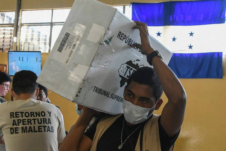 Funcionrio do TSE carrega urna da eleio presidencial de Honduras durante apurao em Tegucigalpa