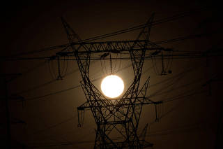 Pylons of high-tension electricity power lines are seen during sunrise in Brasilia