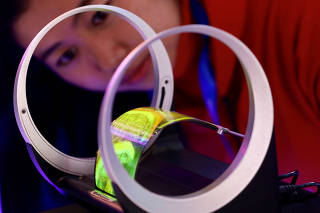 Staff member looks at a foldable screen developed by Visionox, at the fourth World Internet Conference in Wuzhen