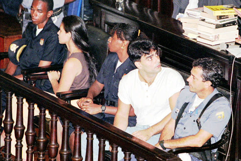 Guilherme de Pádua e Paula Thomaz evitam olhar um para o outro enquanto aguardam o início do julgamento no tribunal, em 1997