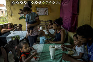 Children eat lunch at a free soup kitchen in a slum in La Guaira, Venezuela.