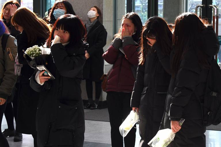 Fs do grupo sul-coreano SHINee se renem em frente ao hospital em que Kim Jong-Hyun morreu, nesta segunda (18)