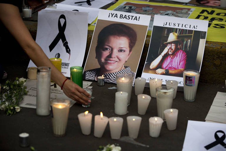 Manifestante coloca velas ao lado das fotos de dois jornalistas mortos neste ano no Mxico