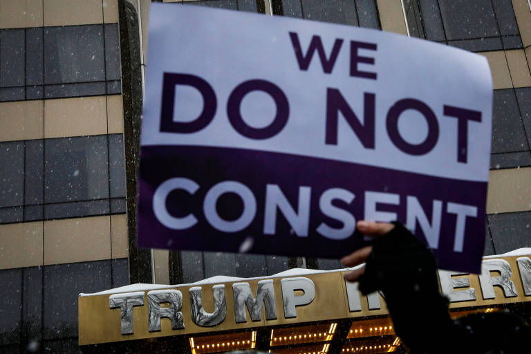 Manifestante carrega cartaz 'Ns no consentimos' em protesto em frente a hotel de Trump em NY