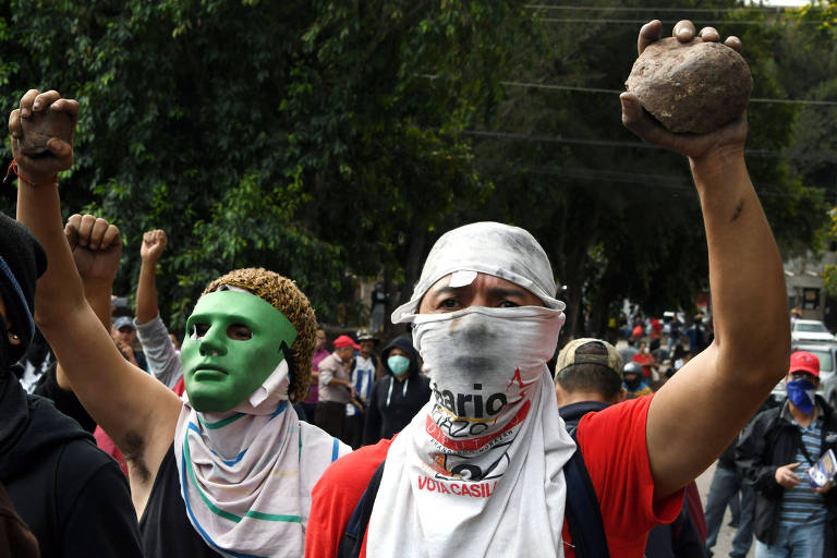 Manifestantes contra governo de Honduras preparam pedras para atirar contra policiais em Tegucigalpa