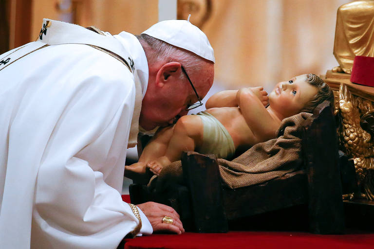 Papa Francisco beija estátua do Menino Jesus durante tradicional Missa do Galo, na Basílica de São Pedro, no Vaticano