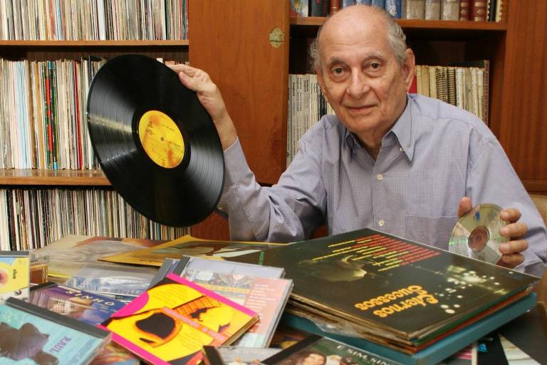 O pesquisador musical Jairo Severiano posa para foto com alguns discos de sua coleção 