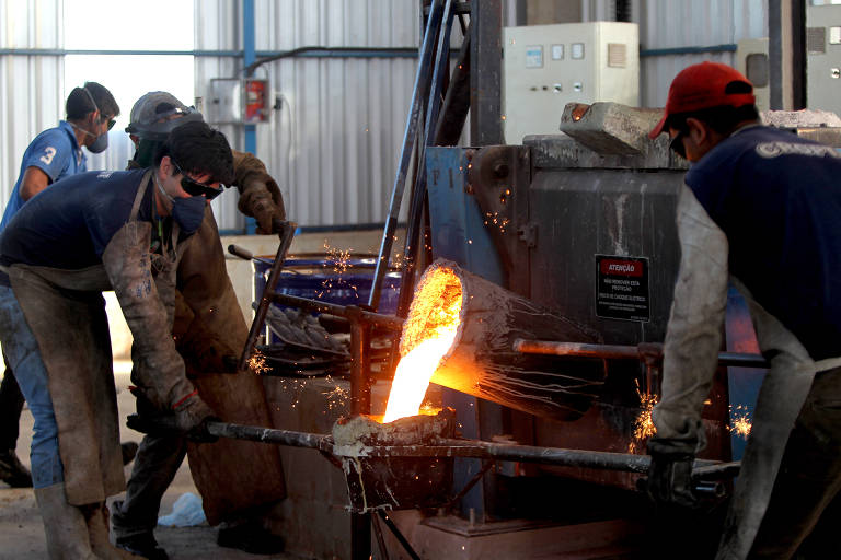 Imagem mostra homens trabalhando numa siderúrgica.