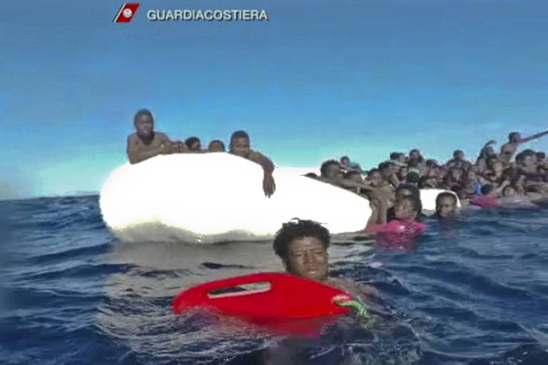 Imagem capturada de vídeo da Guarda Costeira mostra pessoas sendo resgatadas de botes no Mediterrâneo no fim de semana 