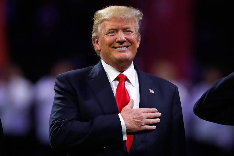 O presidente dos EUA, Donald Trump, se prepara para cantar o hino nacional em estádio de Atlanta