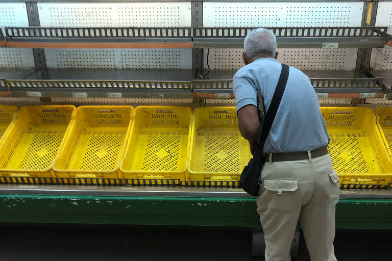 Comprador observa prateleira vazia em supermercado após operação do regime em Caracas
