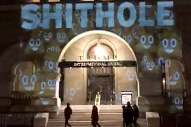 Projeção na fachada de hotel de Trump em Washington com os dizeres 'lugar de merda