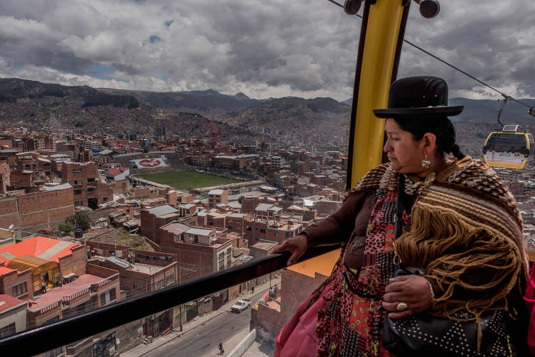 Passageira observa a cidade de La Paz, na Bolívia, a partir do Mi Teleferico
