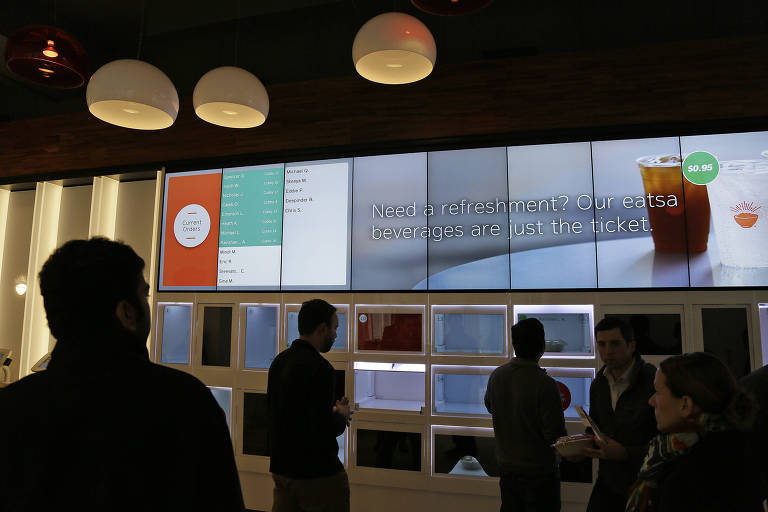 Pessoas aguardam seu almoço na Eatsa, em São Francisco (EUA). O restaurante automatizado não tem caixas, e os pedidos podem ser feitos em quiosques eletrônicos enquanto trabalhadores preparam a refeição atrás de uma parede opaca, com virtualmente nenhuma interação com os clientes
