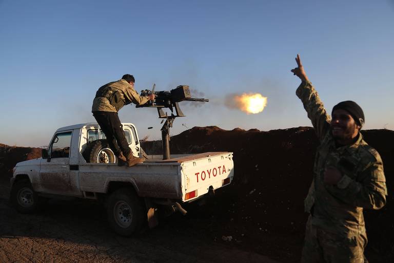 Combatentes do Exército Libre Sírio, apoiados pela Turquia, disparam contra posições das Unidades de Proteção do Povo Turco em Tal Malid 