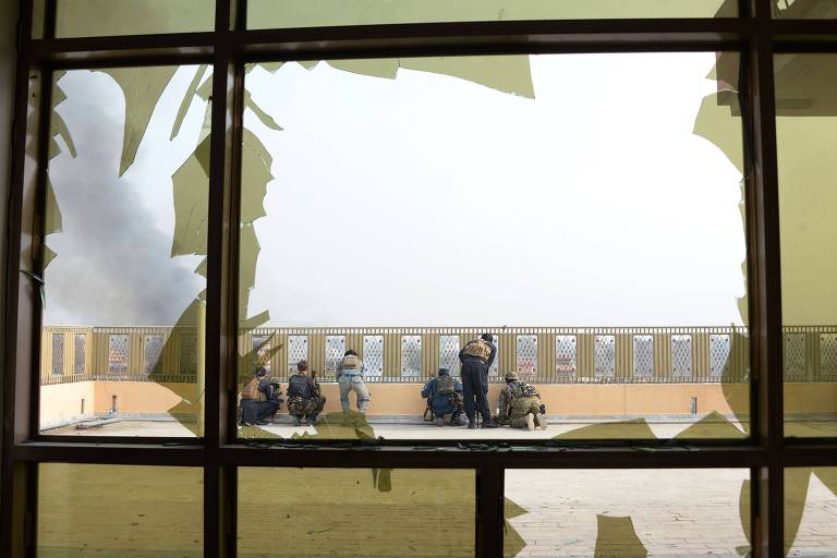 Soldados se preparam para entrar no prédio da Save the Children durante o ataque em Jalalabad 