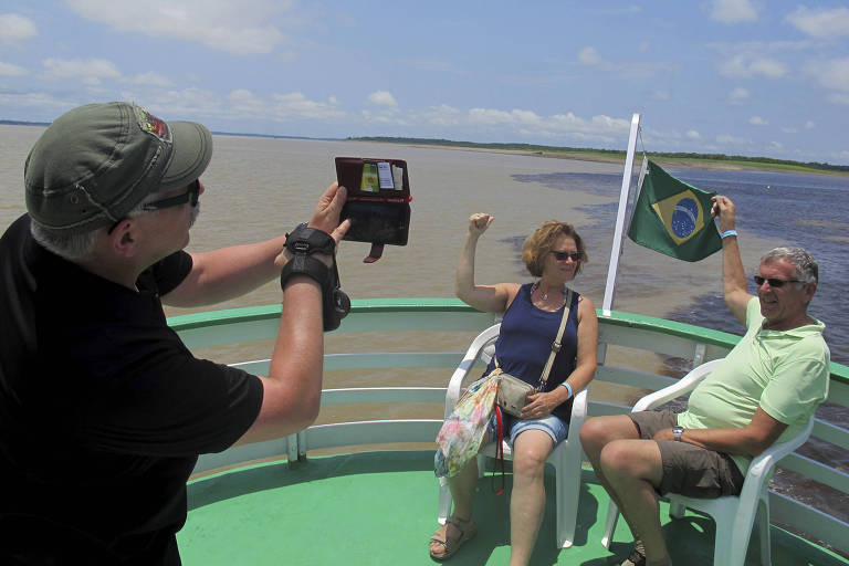 Turistas tiram fotos no encontro dos rios Solimões e Negro; Brasil lança visto eletrônico para americanos