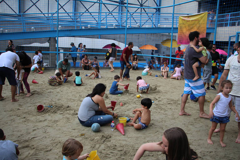 Crianças brincando na quadra de areia montada na praça externa do Sesc Vila Mariana