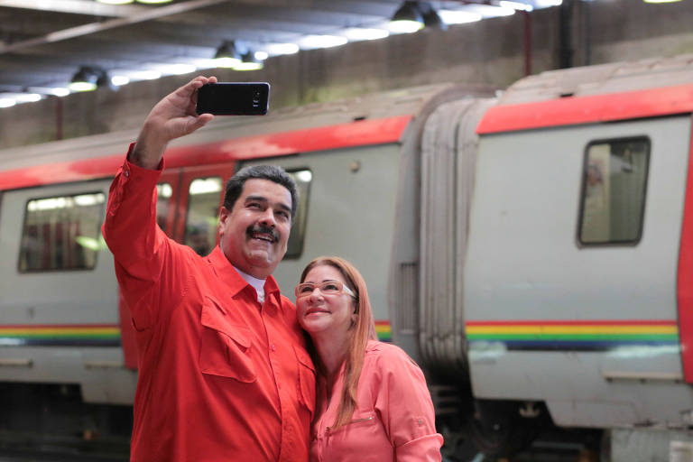O líder venezuelano, Nicolás Maduro, tira foto com a mulher, Cilia Flores, na oficina do metrô de Caracas