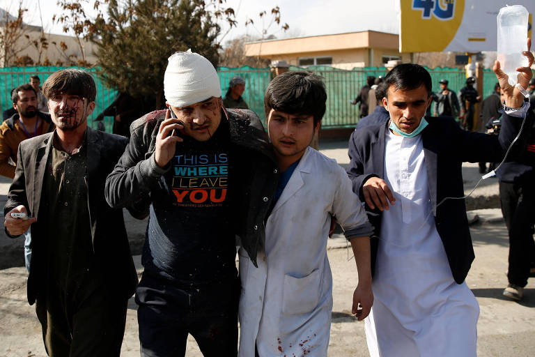 Homens auxiliam ferido na explosão