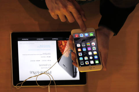 FILE - In this Sept.19, 2014 file photo, a customer checks the iPhone 6, in Paris. A French prosecutor office said Tuesday Jan.9, 2018 an investigation into Apple over alleged planned obsolescence of some of its smartphones has been opened. It follows a legal complaint filed in December by pro-consumer group Halte a l'obsolescence programmee (Stop Planned Obsolescence). Under a 2015 law, it is banned to intentionally shorten lifespan of a product in order to incite customers replace it. (AP Photo/Christophe Ena, File) ORG XMIT: PAR101