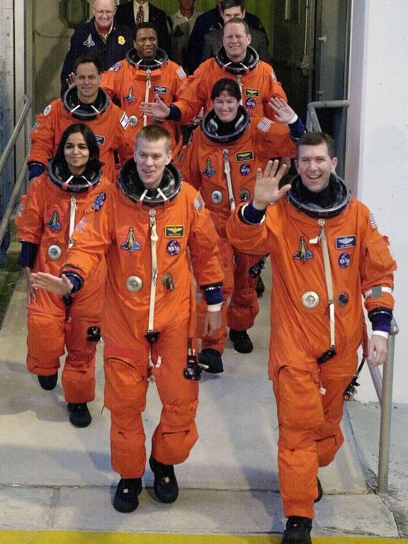 Astronautas do Columbia, Rick Husband puxa a fila, seguido por McCool, pelas mulheres Kalpana Chawla (esq.) e Laurel Clark e por Ilan Ramon (no alto, à esq.), David Brown (centro) e Michael Anderson 