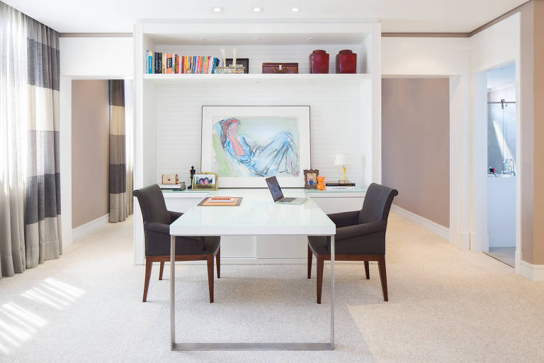 Um quarto anexo à suíte desse apartamento no Morumbi (zona oeste da capital paulista) foi transformado em área de trabalho pelo escritório Larsson Mantovani. 
A parede que separava os dois dormitórios foi derrubada e deu lugar a uma estante de laca branca para acomodar livros. A mesa foi encostada no móvel para ganhar espaço.