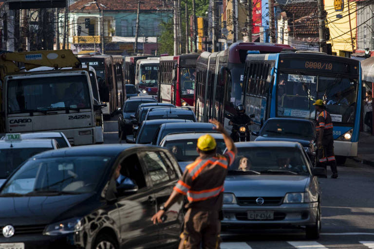 Agente da CET desvia o trânsito em avenida de São Paulo 
