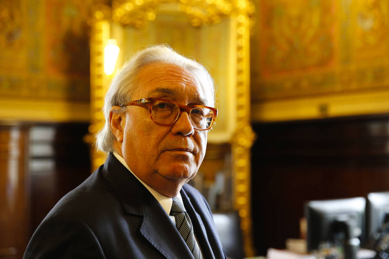 O desembargador Manoel de Queiroz Pereira Calças, novo presidente do TJ posa em seu gabinete; grisalho, ele usa terno, gravata e óculos