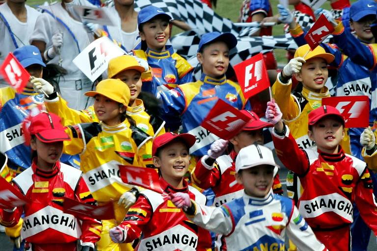 Crianças desfilam com bandeira da F-1 durante o GP de Xangai de 2004