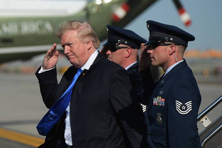 O presidente dos EUA, Donald Trump, bate continência a militares de sua escolta ao chegar ao aeroporto de Newark, perto de Nova York, em junho