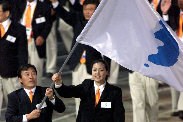 Jang Choo Pak (esq), da Coreia do Norte, e Eun-Soon Chung, da Coreia do Sul, desfilam juntos na abertura dos Jogos de Sydney-2000