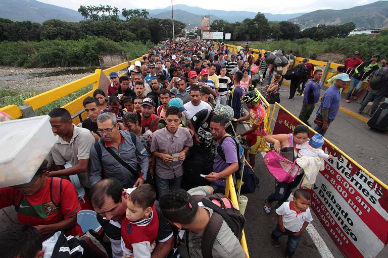 Venezuelanos cruzam a ponte que separa o país da Colômbia