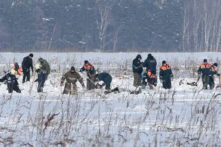 Russian Emergency Situations Ministry members work at the crash site of the AN-148 airplane in Moscow Region