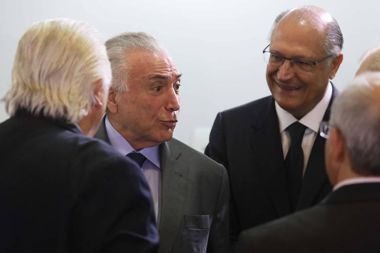 De terno e gravata, o presidente Michel Temer conversa com o governador Geraldo Alckmin, à sua direita, e outros convidados durante visita ao Projeto Sirius, em Campinas (SP)