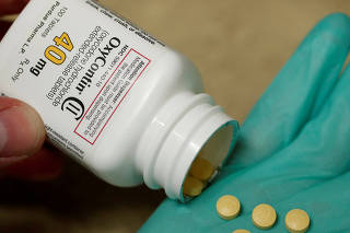 FILE PHOTO: A pharmacist holds prescription painkiller OxyContin at a local pharmacy in Provo