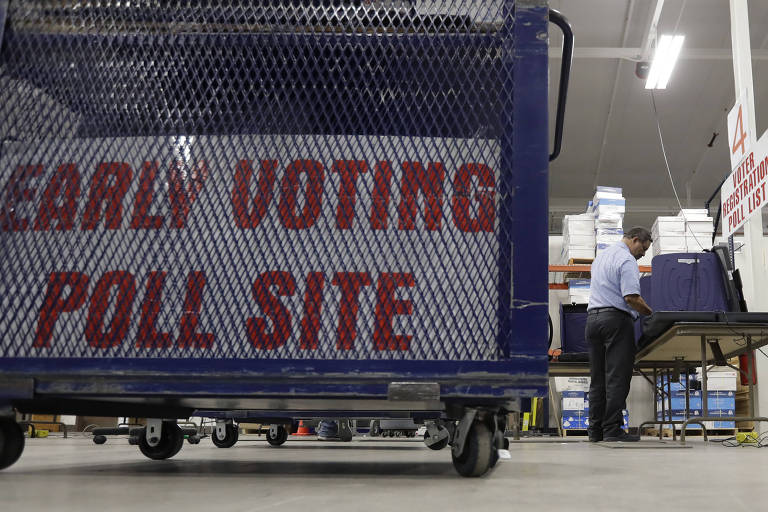 Funcionário preparam máquinas de votação no condado de Bexar, no Texas; governo indicia 13 russos por interferência em eleição de 2016