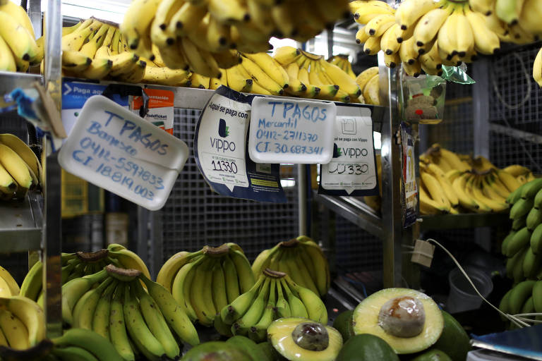 Barraca de frutas no mercado de Chacao, em Caracas, com informações de pagamento por apps