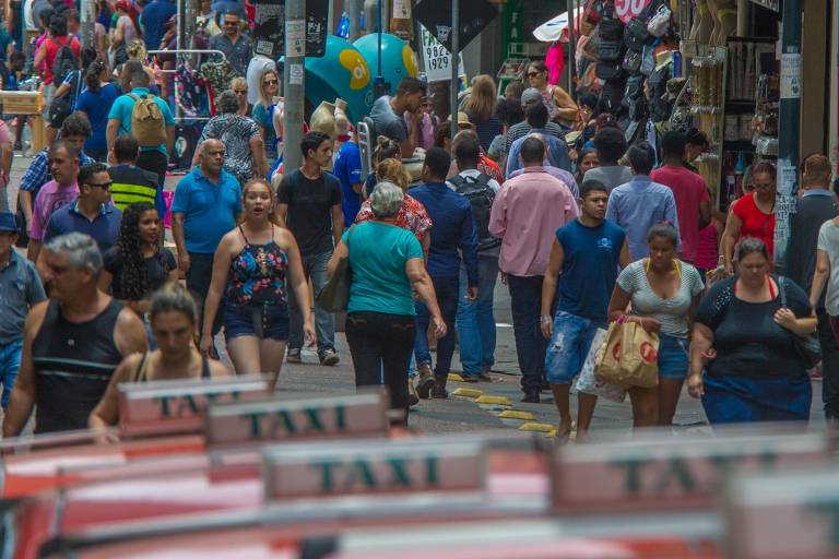 Pessoas andam por rua comercial da capital gaúcha 