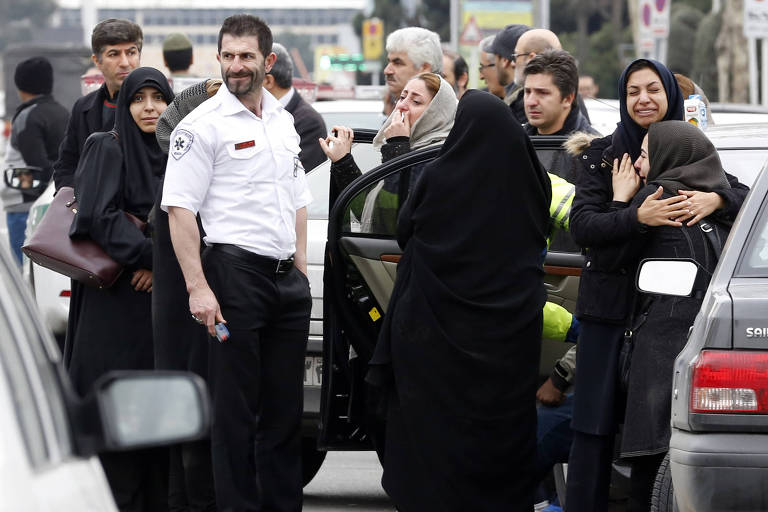 Familiares de passageiros iranianos do voo da Aseman, que caiu nas montanhas, se reúnem ao redor do aeroporto de Teerã