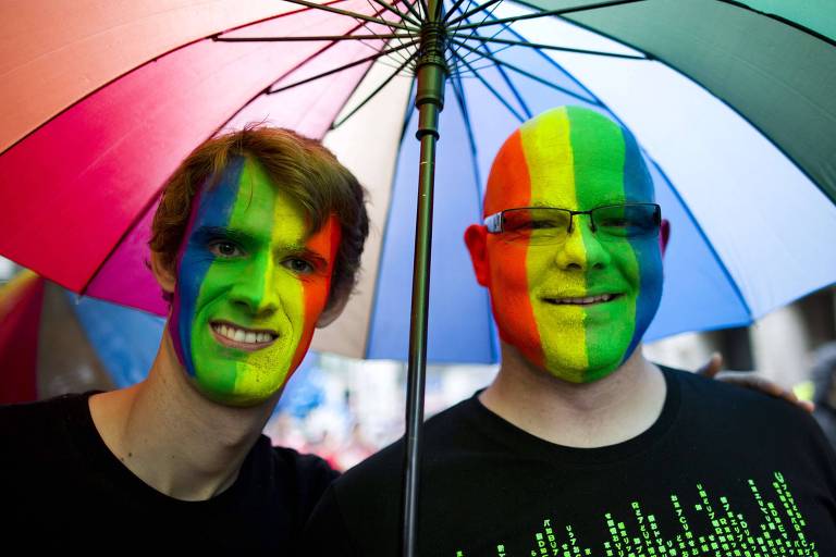Homens com rosto pintado com as cores da bandeira do orgulho LGBT participam de parada em Londres em 2014