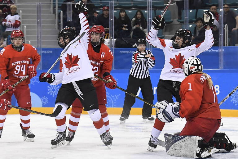 Jogadoras canadenses comemoram ponto em partida contra a Rússia
