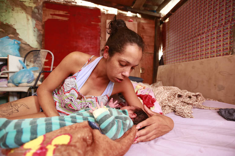 A ex-presa Jéssica Monteiro, 24, faz carinho no filho em casa