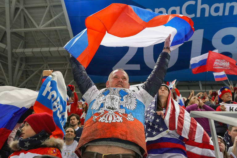 Torcedor russo festeja com a bandeira do país durante uma partida de hóquei masculino disputada contra os EUA, nos Jogos de Inverno de PyeongChang