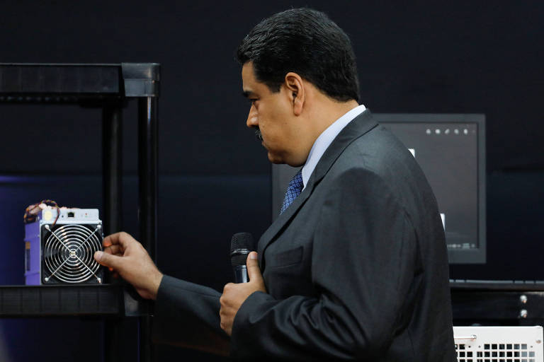 O líder venezuelano, Nicolás Maduro, examina computador usado para minerar o petro em evento no Palácio de Miraflores