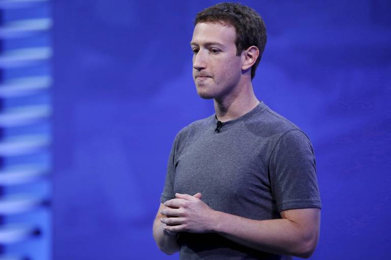 O CEO do Facebook, Mark Zuckerberg, de camiseta cinza, com as mãos em frente ao peito e fazendo careta com a boca cerrada, demonstrando preocupação