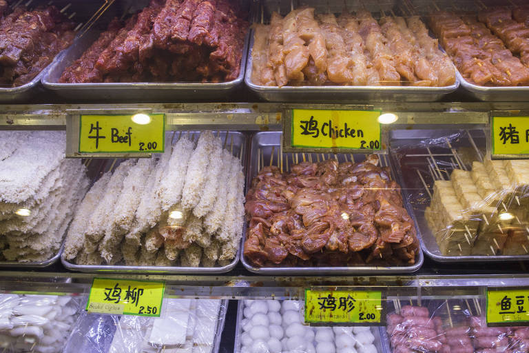 Comidas asiáticas expostas em três prateleiras de uma vitrine