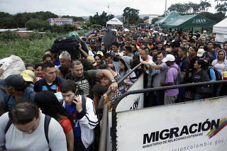 People queue to try to cross into Venezuela from Colombia through the Simon Bolivar international bridge in Cucuta