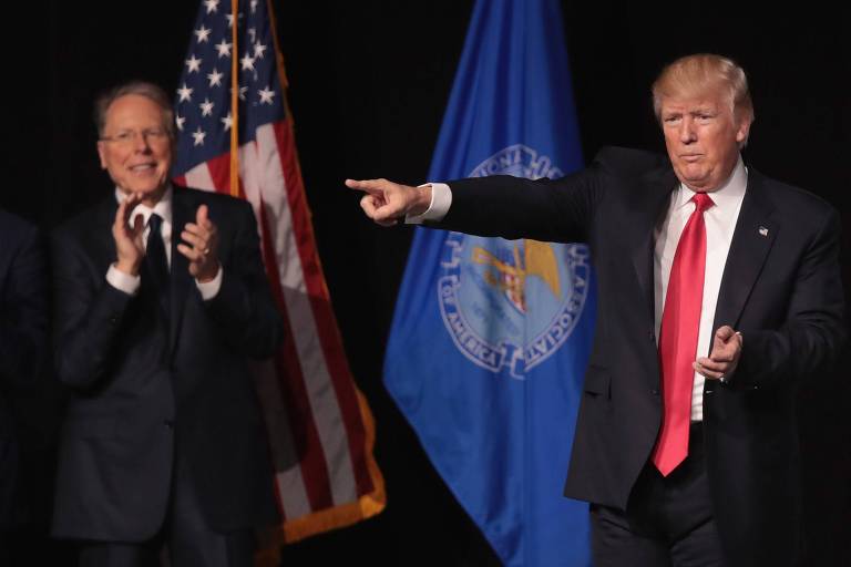 O executivo-chefe da Associação Nacional do Rifle, Wayne LaPierre, aplaude o presidente Donald Trump em evento da entidade em abril de 2017